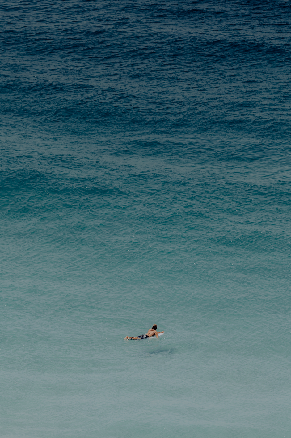 Australian Prints by Mackenzie Sweetnam. An image of a surfer heading out into the ocean in Queensland, Australia.