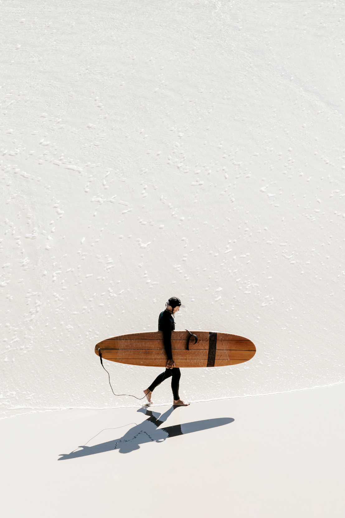 Australian Prints by Mackenzie Sweetnam.  A lone surfer walks along the shoreline in Queensland, Australia.