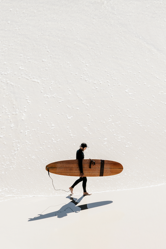 Australian Prints by Mackenzie Sweetnam.  A lone surfer walks along the shoreline in Queensland, Australia.