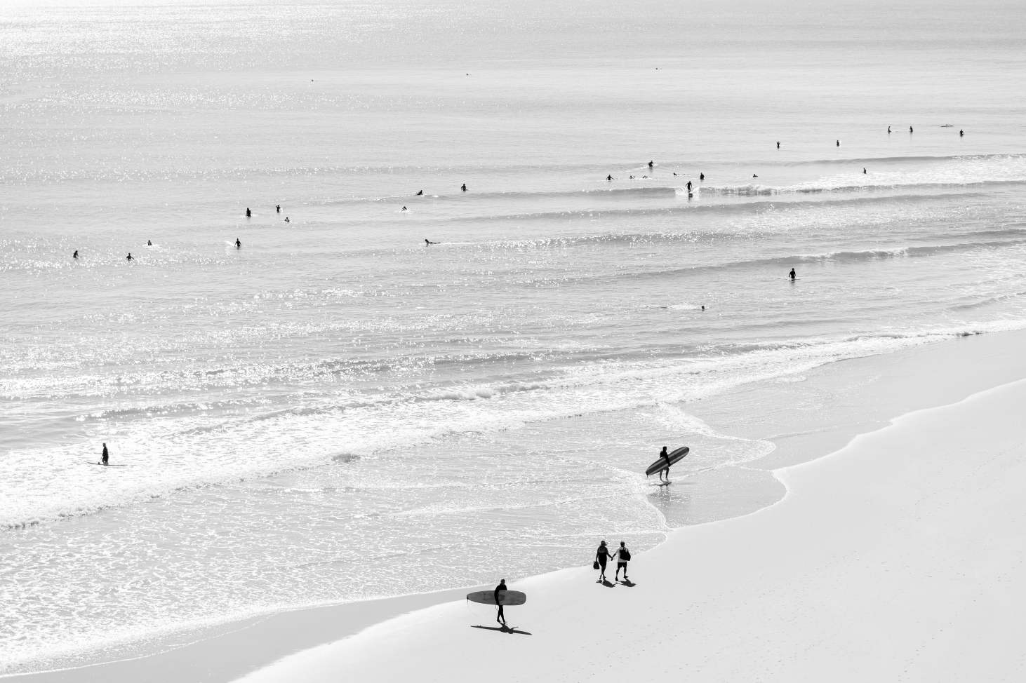 Australian Prints by Mackenzie Sweetnam. A black and white print of early bird surfers and swimmers in Queensland.