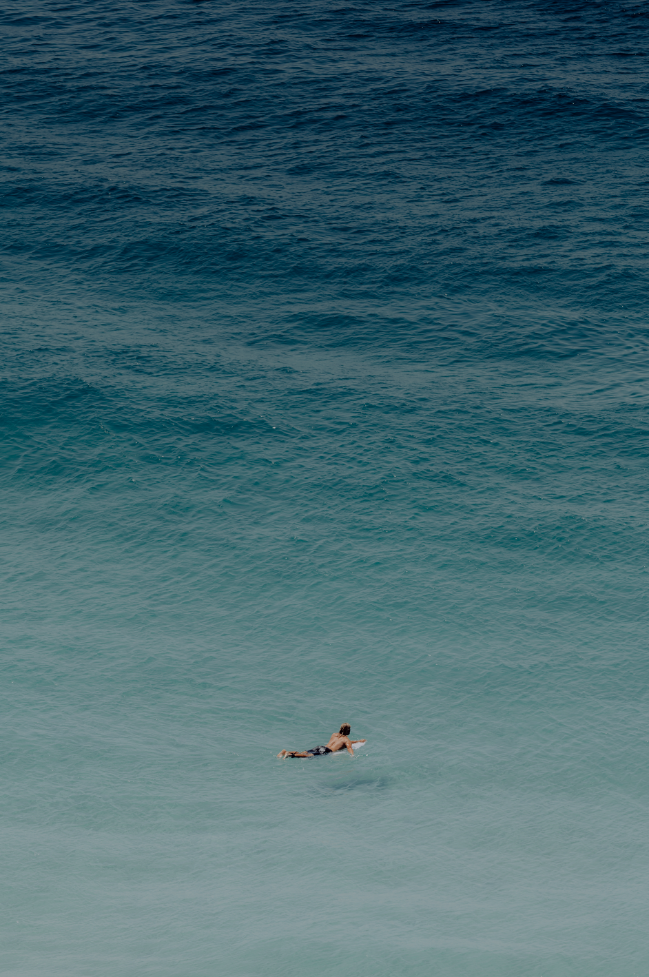 Australian Prints by Mackenzie Sweetnam. An image of a surfer heading out into the ocean in Queensland, Australia. 