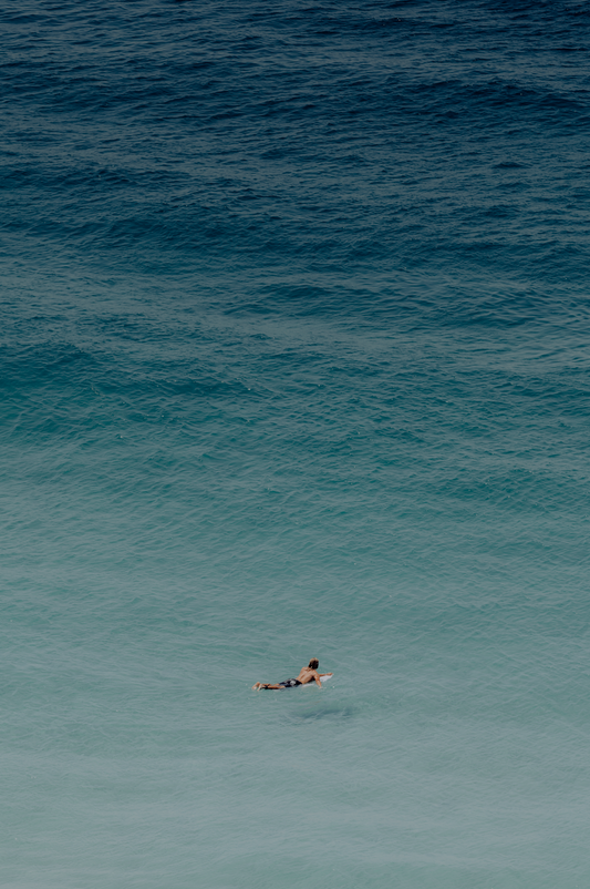 Australian Prints by Mackenzie Sweetnam. An image of a surfer heading out into the ocean in Queensland, Australia. 